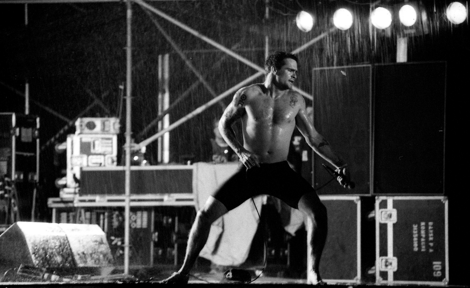 Rollins, shirtless, on stage and in the rain